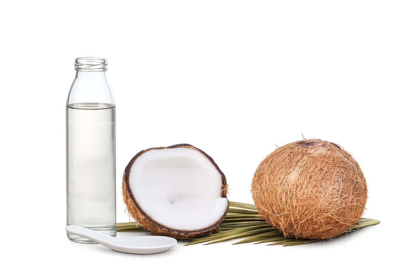Virgin coconut oil in a glass jar beside fresh coconut